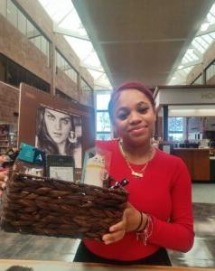 Student Ameenah Perez holding the basket with art supplies that she won